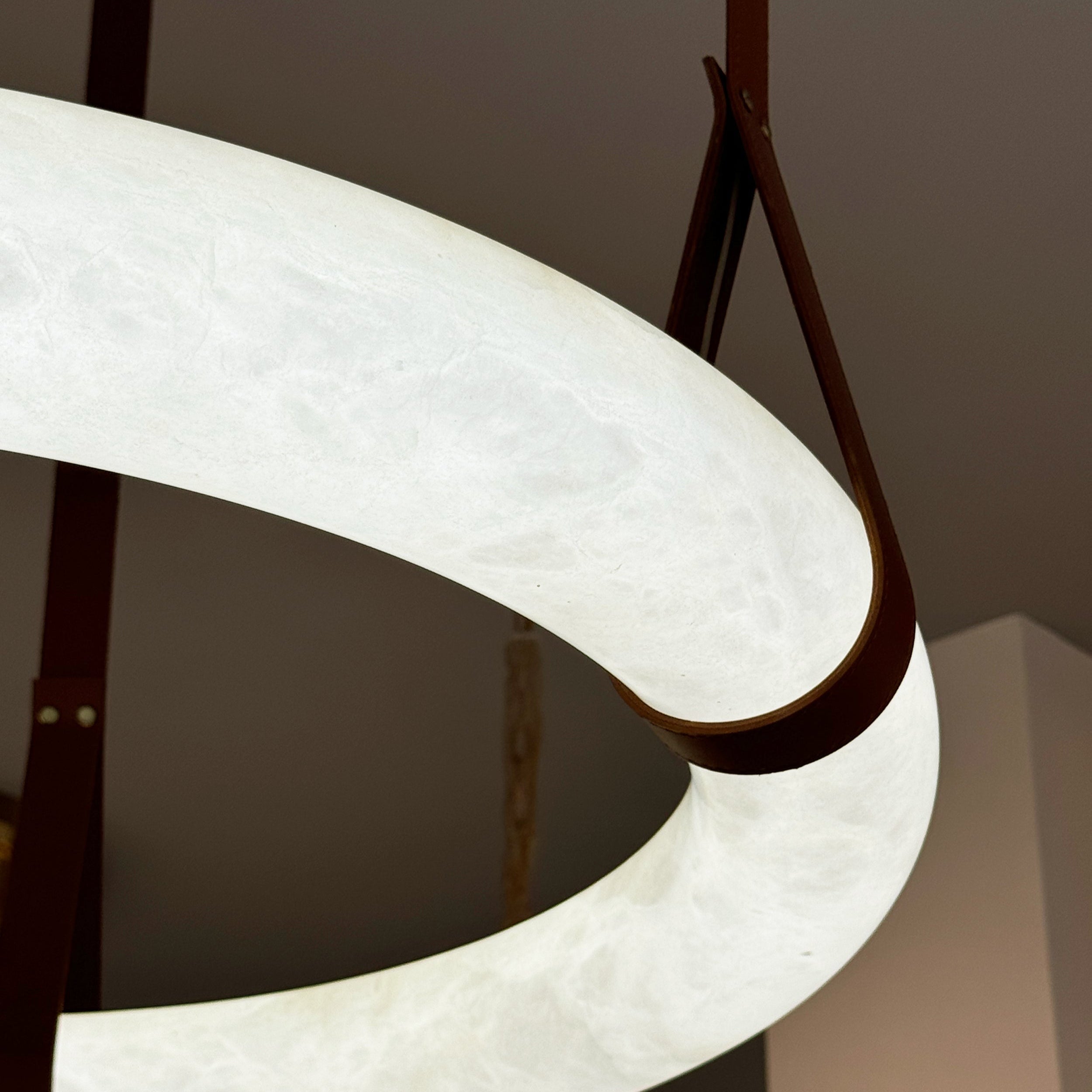 Close-up of leather suspension detail on marble ceiling light