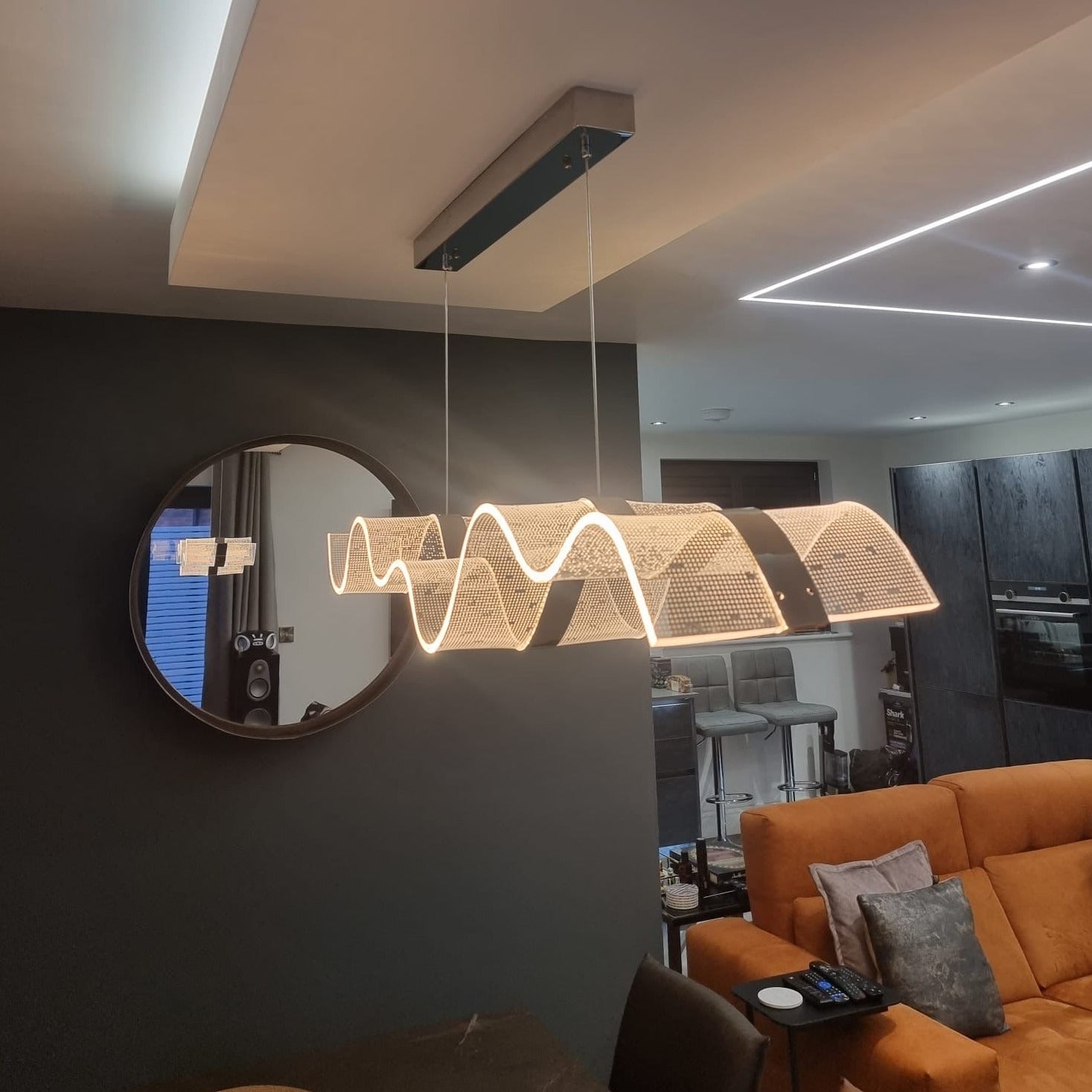 Curved rectangular chandelier installed in modern living room