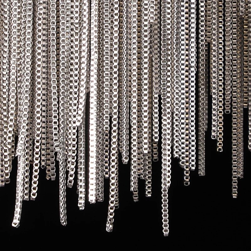 Macro detail of cascading metal chains on modern wall light