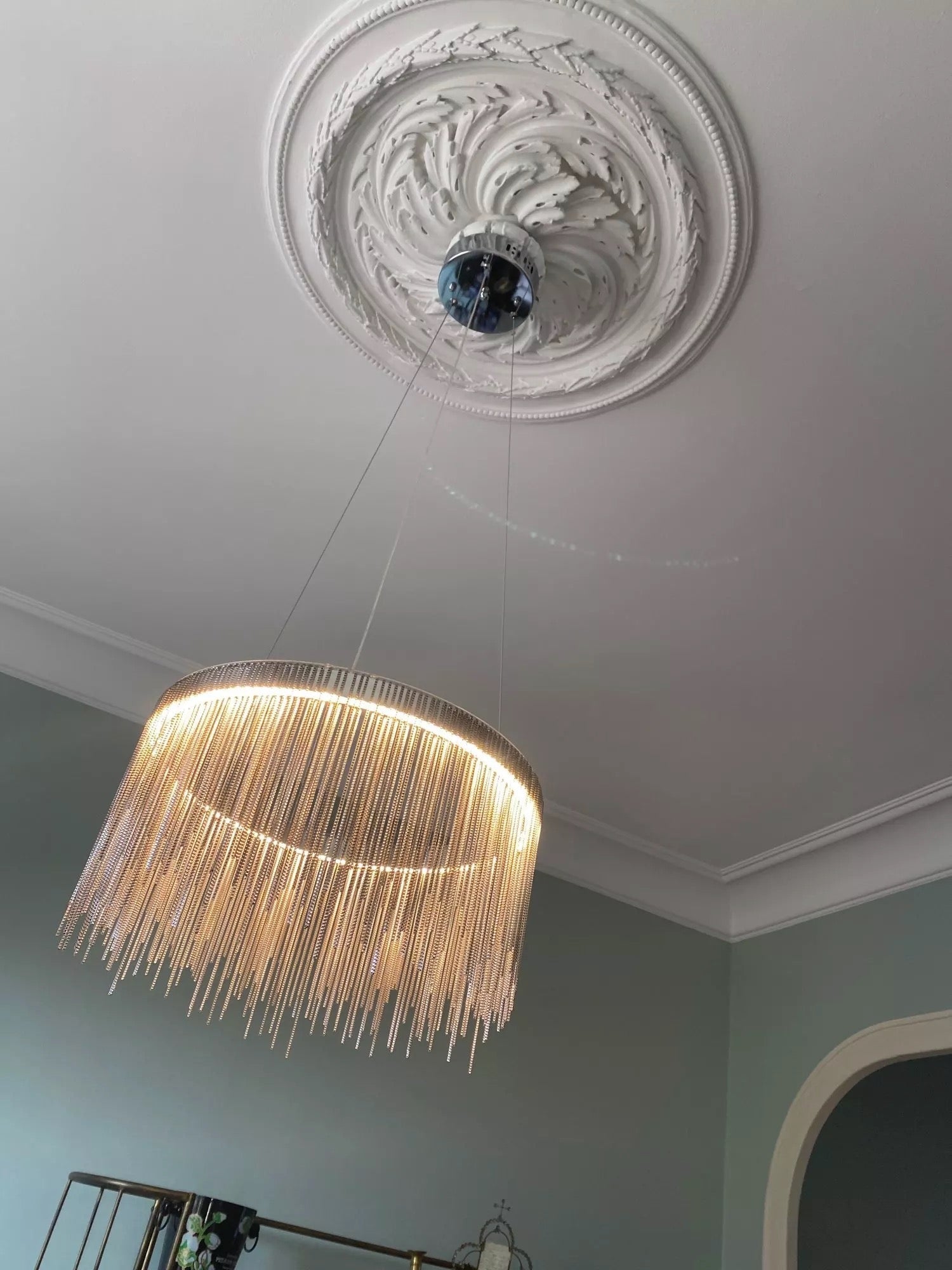 Ceiling mounted circular chandelier with cascading chains in UAE home