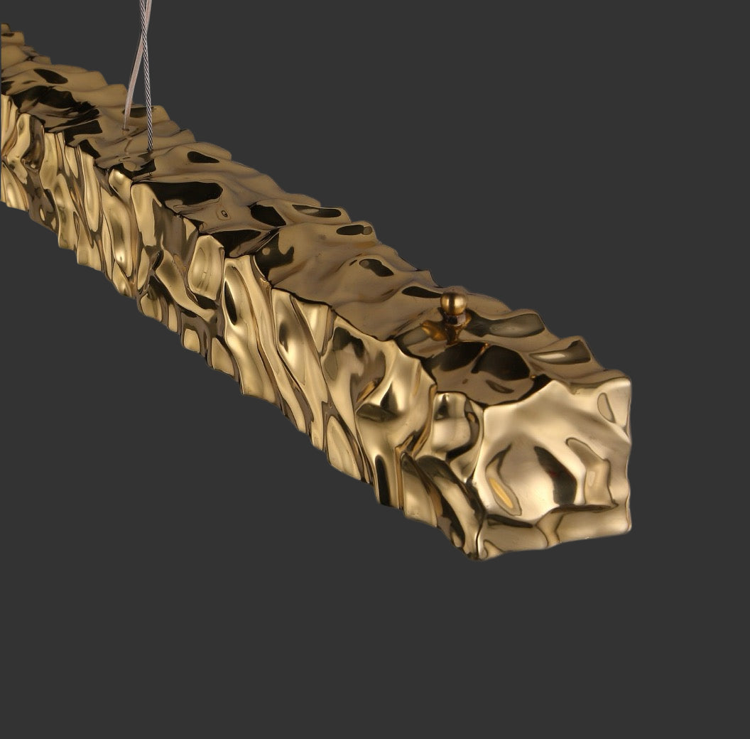 Close-up of the textured gold pendant element on the Ecliptica staircase chandelier by VORELLI®