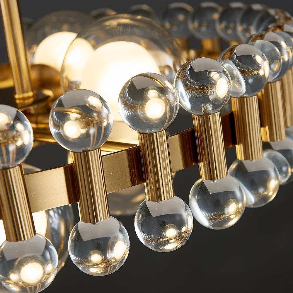 Close up clear glass spheres on Alytus Rectangular Chandelier II gold frame