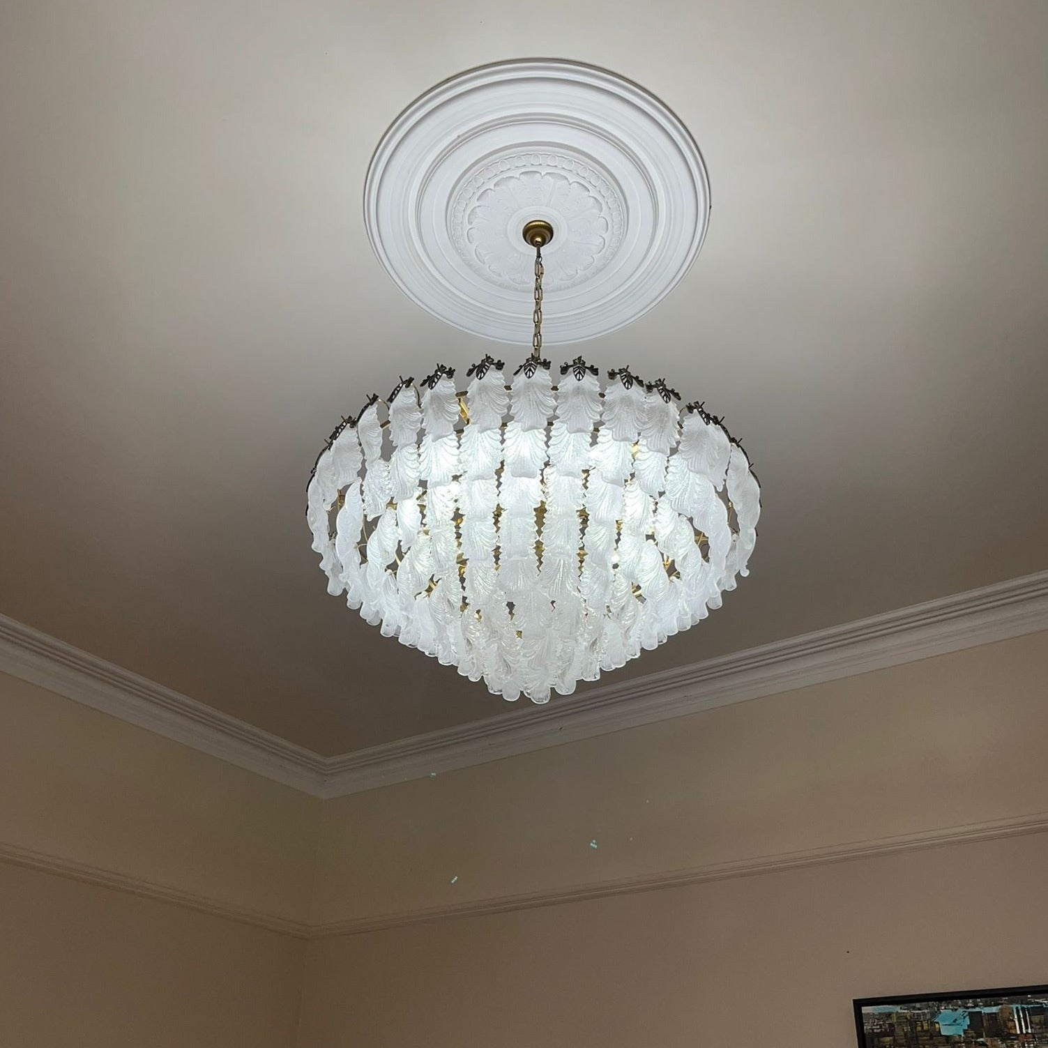 Circular crystal chandelier design viewed from below highlighting feather shaped crystal arrangement