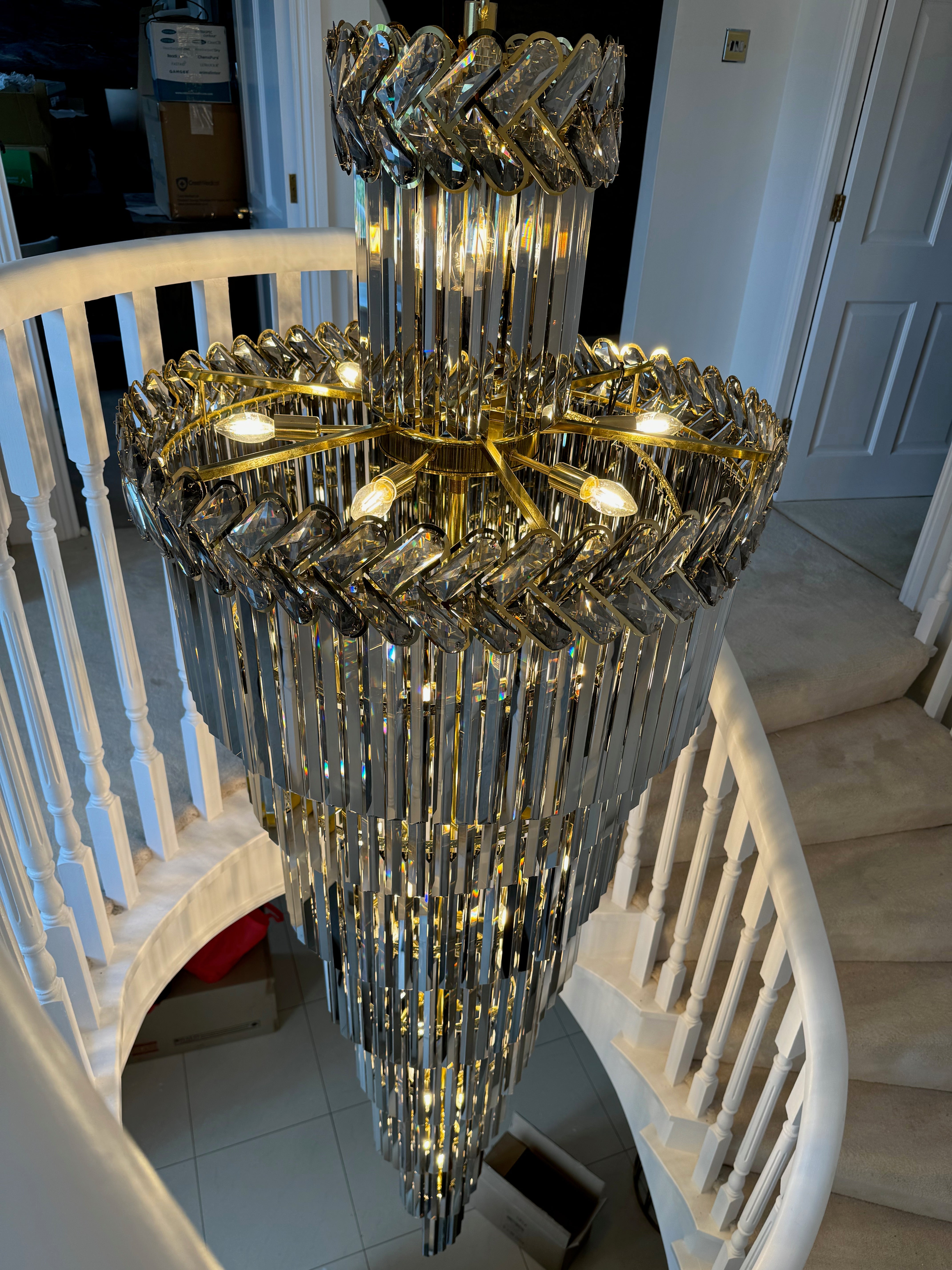 Tiered crystal detail of the Knightsbridge spiral staircase chandelier showing faceted glass and gold frame