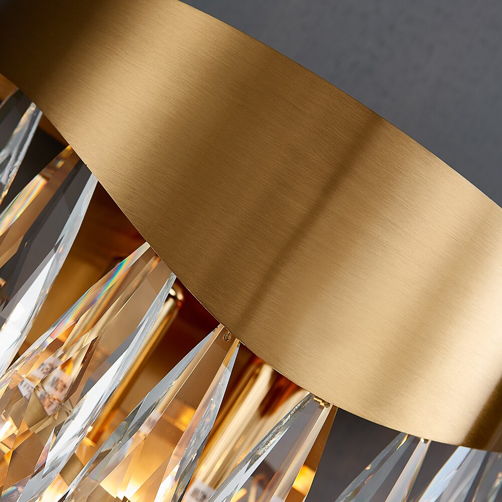 Angled detail of the gold wall light frame with suspended teardrop crystal elements