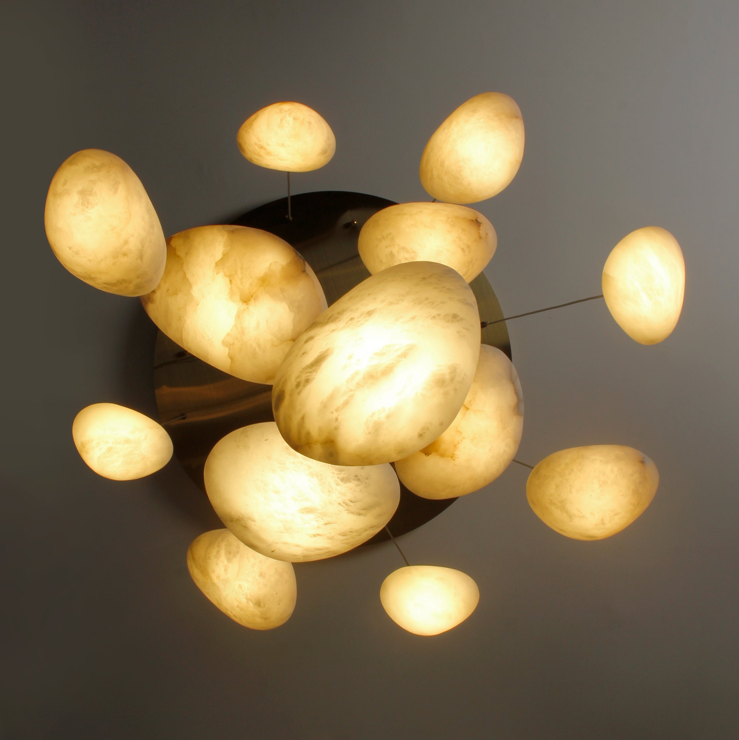 Illuminated marble pendants with warm glow on staircase chandelier