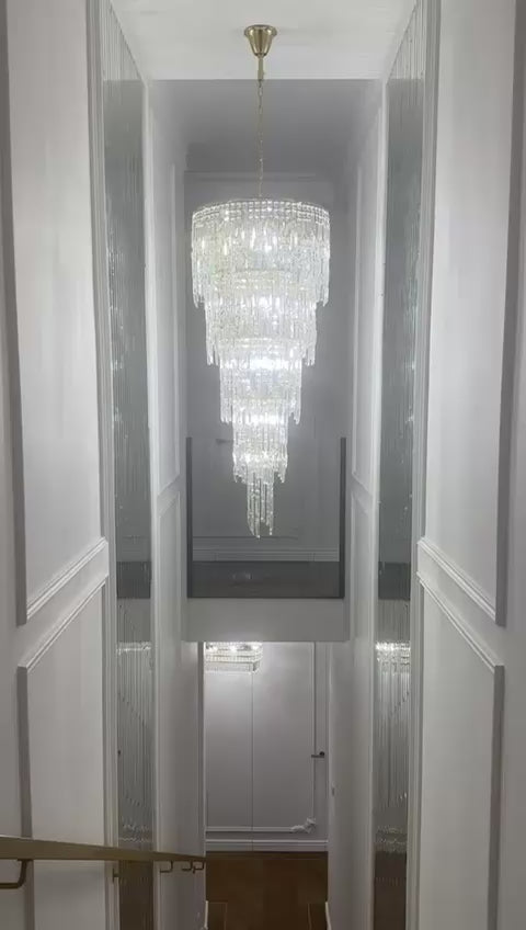 VORELLI® Abruzzi spiral crystal staircase chandelier showcased in a luxury double-height stairwell, highlighting cascading diamond cut faceted crystals and vertical drop design