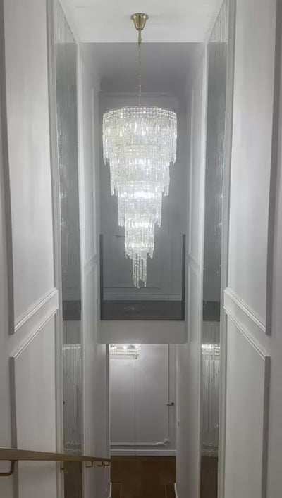 VORELLI® Abruzzi spiral crystal staircase chandelier showcased in a luxury double-height stairwell, highlighting cascading diamond cut faceted crystals and vertical drop design