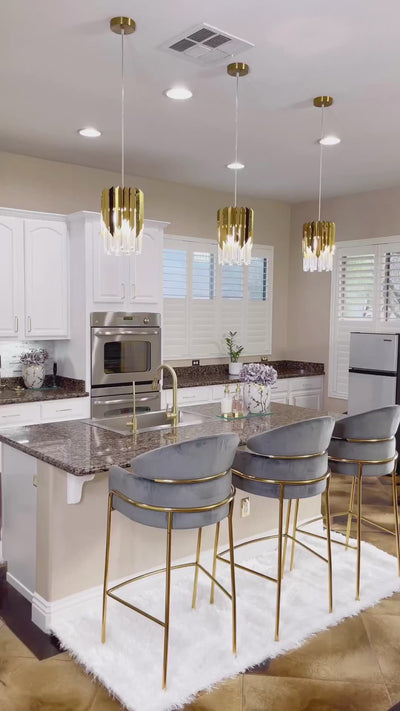 Three VORELLI Manhattan Pendant lights above a modern kitchen island with warm crystal illumination