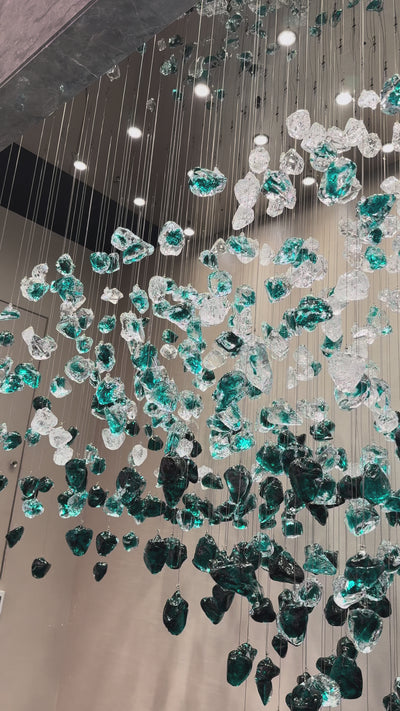 VORELLI Basilica pendant staircase chandelier with green to white gradient stone in a large luxury hospitality project