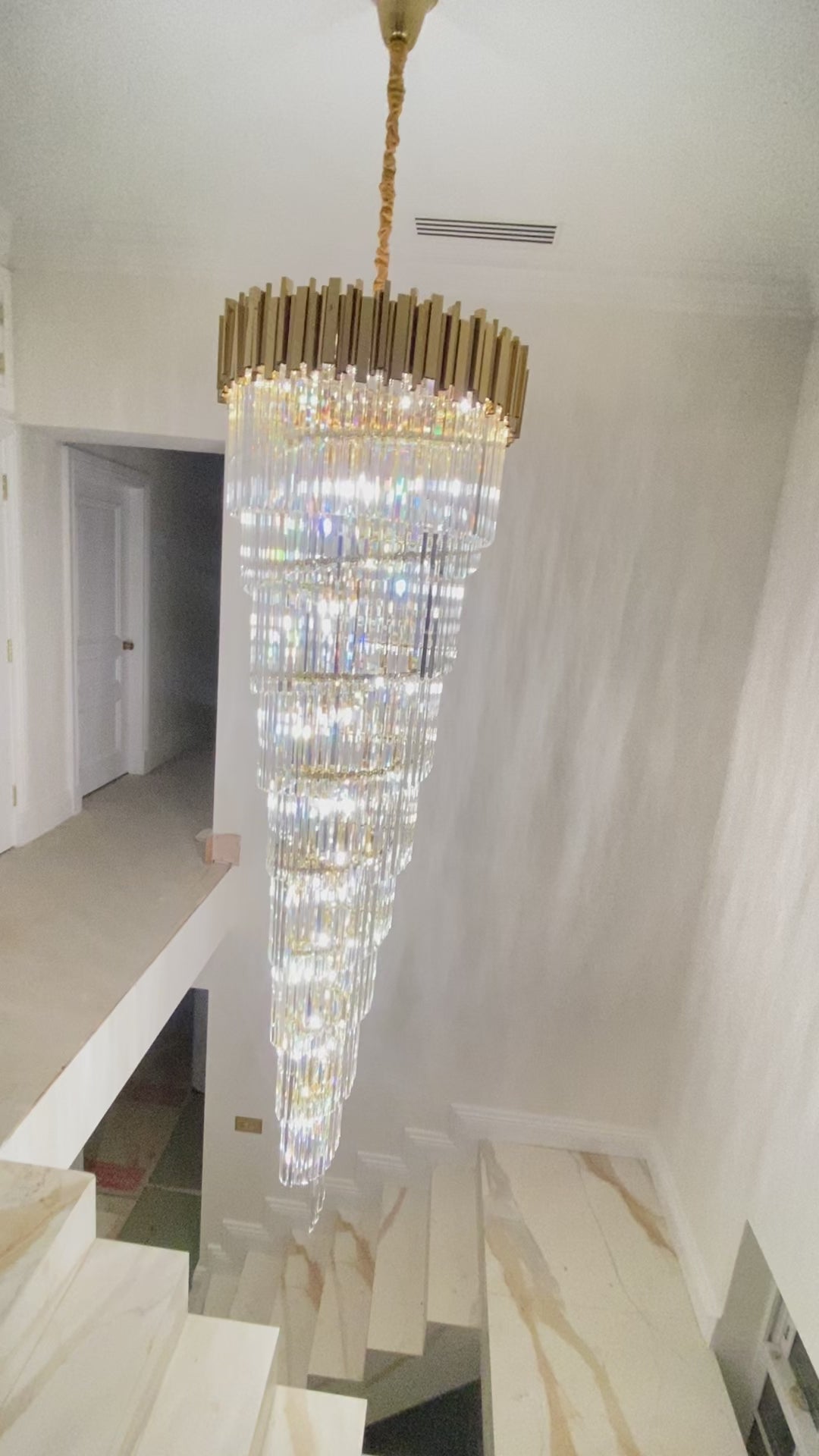Full-length view of the Boeotia Spiral Staircase Chandelier showing its spiralling crystal bars and gold tubular frame.