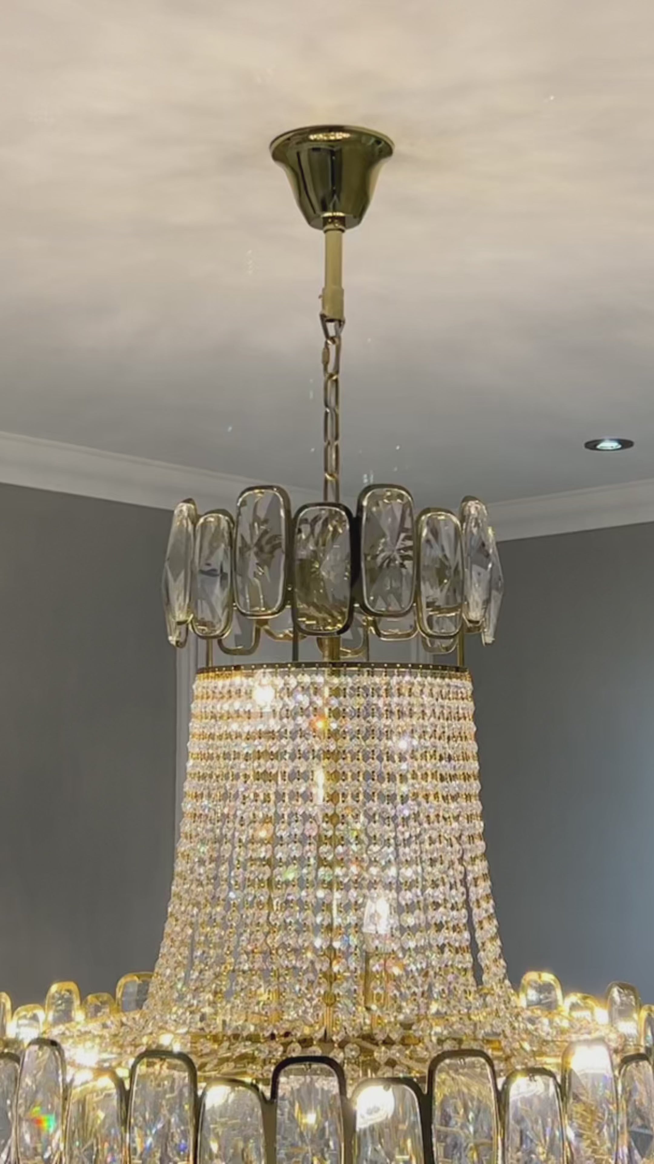 Elegant Edison Grandeur crystal staircase chandelier illuminating a multi-level luxury home by VORELLI®