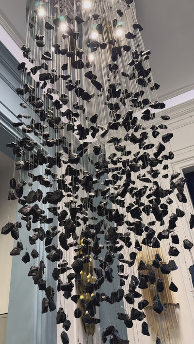 VORELLI Basilica pendant staircase chandelier featuring cascading black stone in a luxury double height interior