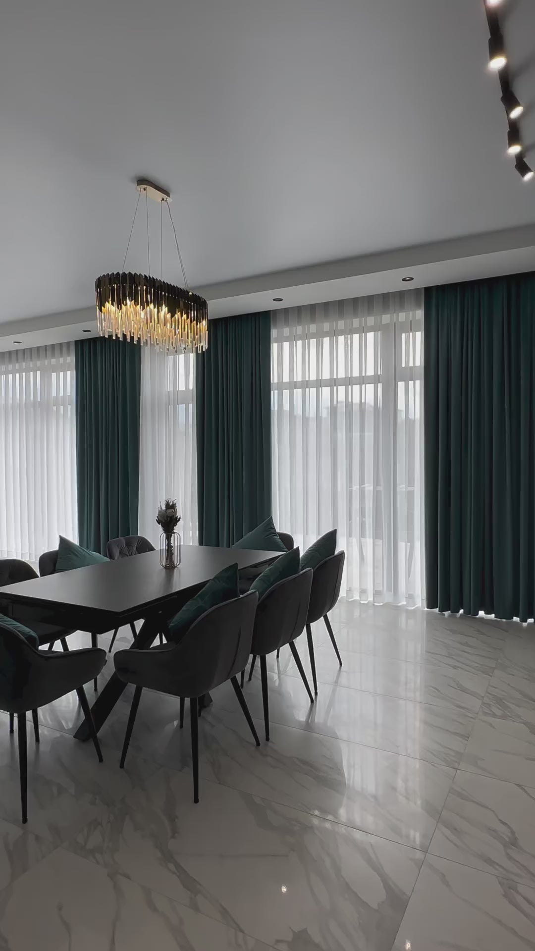 Angled view of VORELLI Manhattan Rectangular Chandelier with illuminated crystal bars in a contemporary dining space