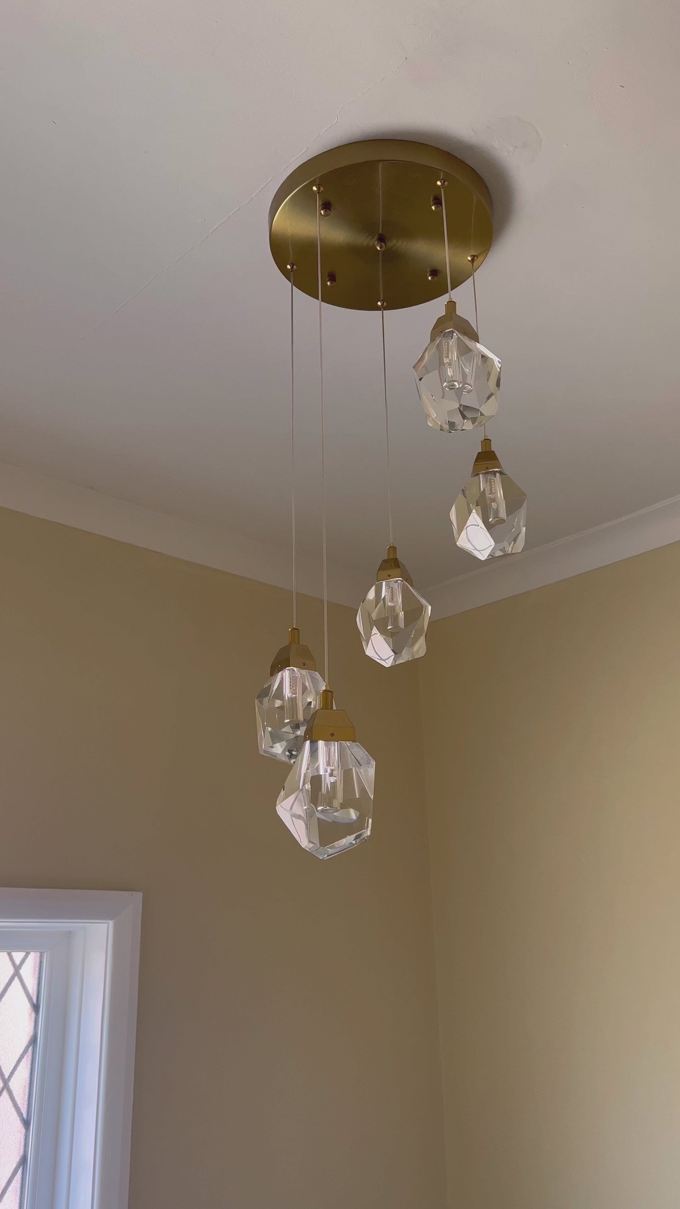 Runtz pendant cluster chandelier suspended in a double height stair space