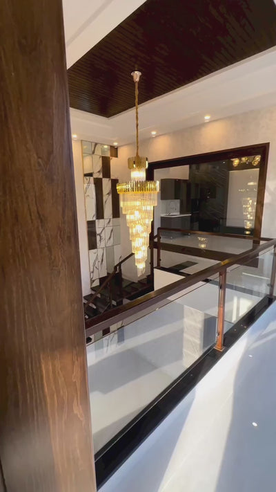VORELLI® Manhattan crystal spiral staircase chandelier illuminating a contemporary stairwell with matching luxury wall lighting and elegant architectural space.