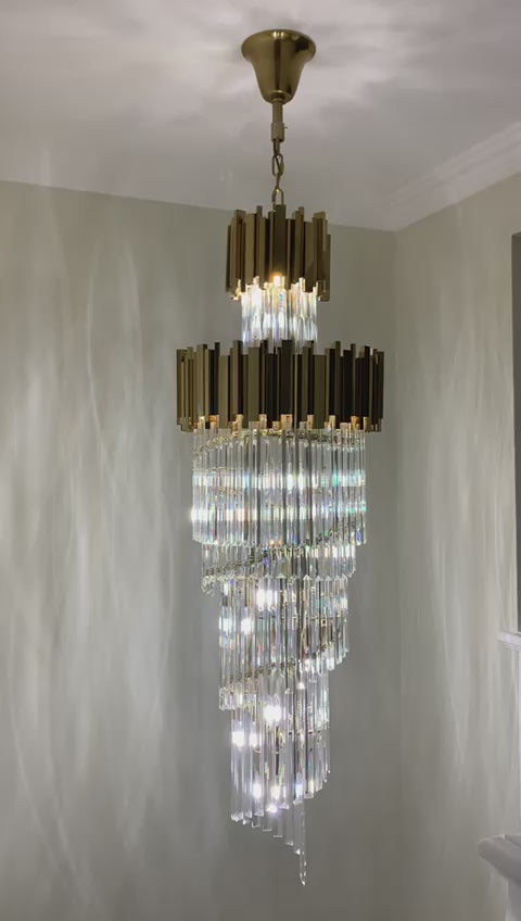 Full-length view of the Boeotia Spiral Staircase Chandelier II with its elegant spiral crystal formation and gold cuboid tubing.