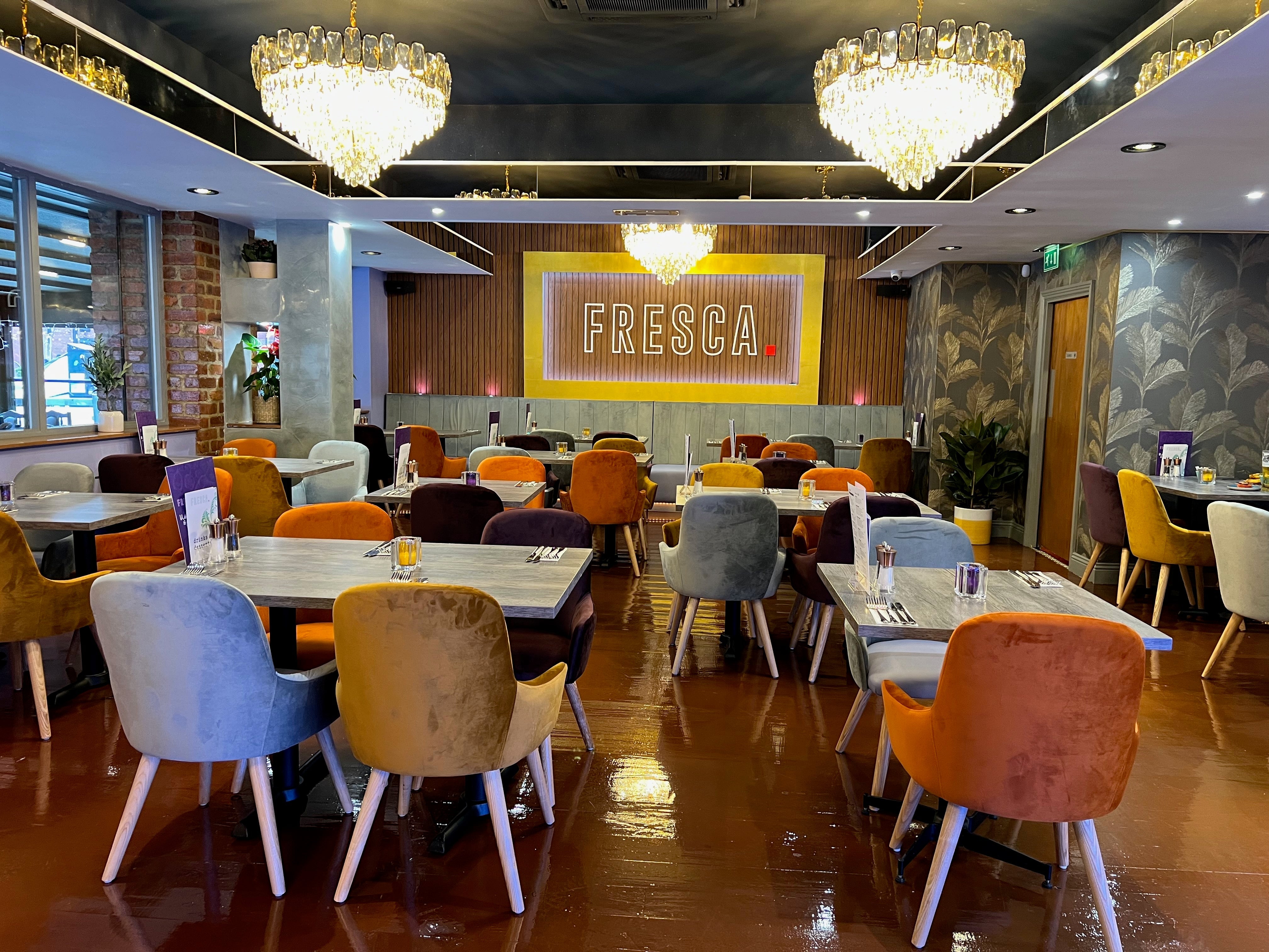 Wide restaurant interior featuring VORELLI Edmond circular crystal chandelier installation