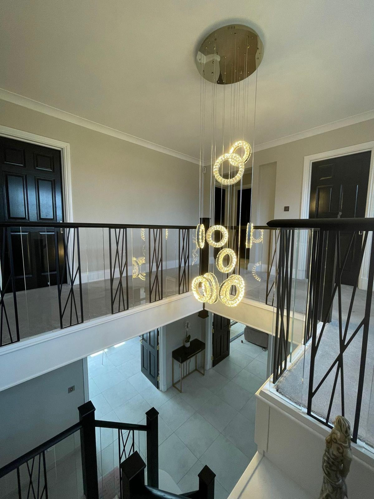 Modern Farnham pendant chandelier cascading through a stairwell space with minimalist architectural styling