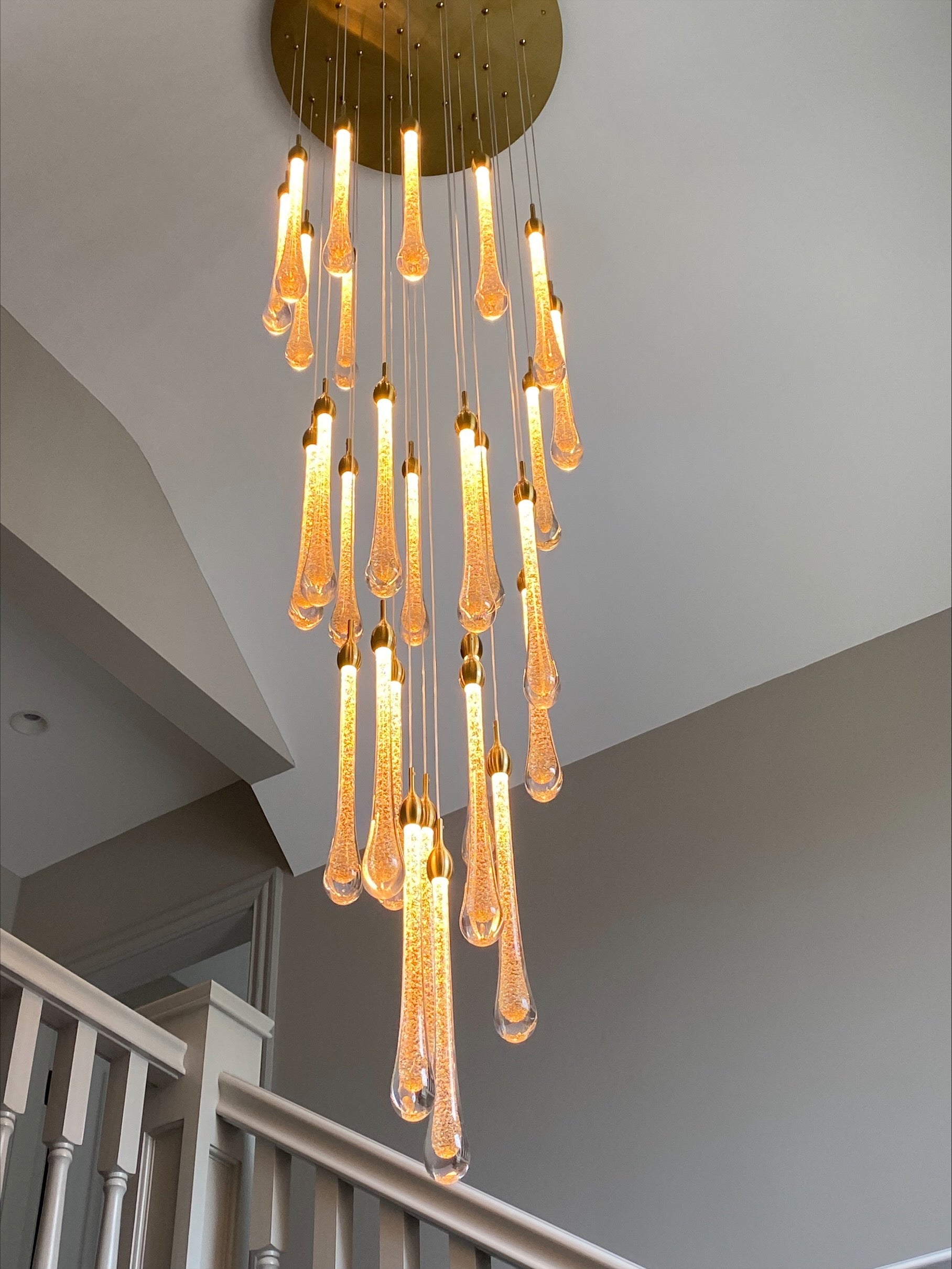 Long cascading gold pendant staircase chandelier by VORELLI Foshan in modern interior