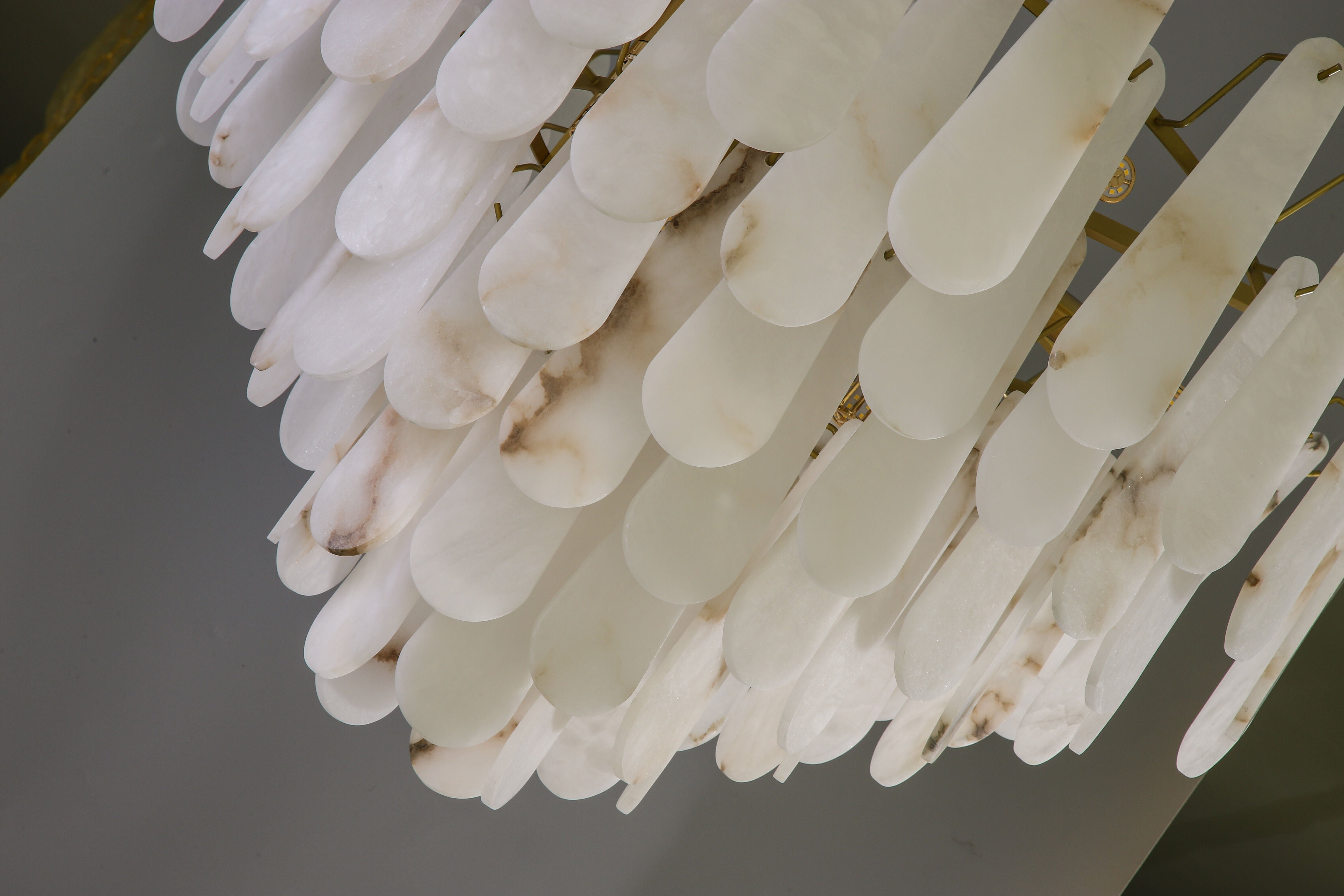 Detailed texture of illuminated marble elements on the VORELLI Maretto chandelier