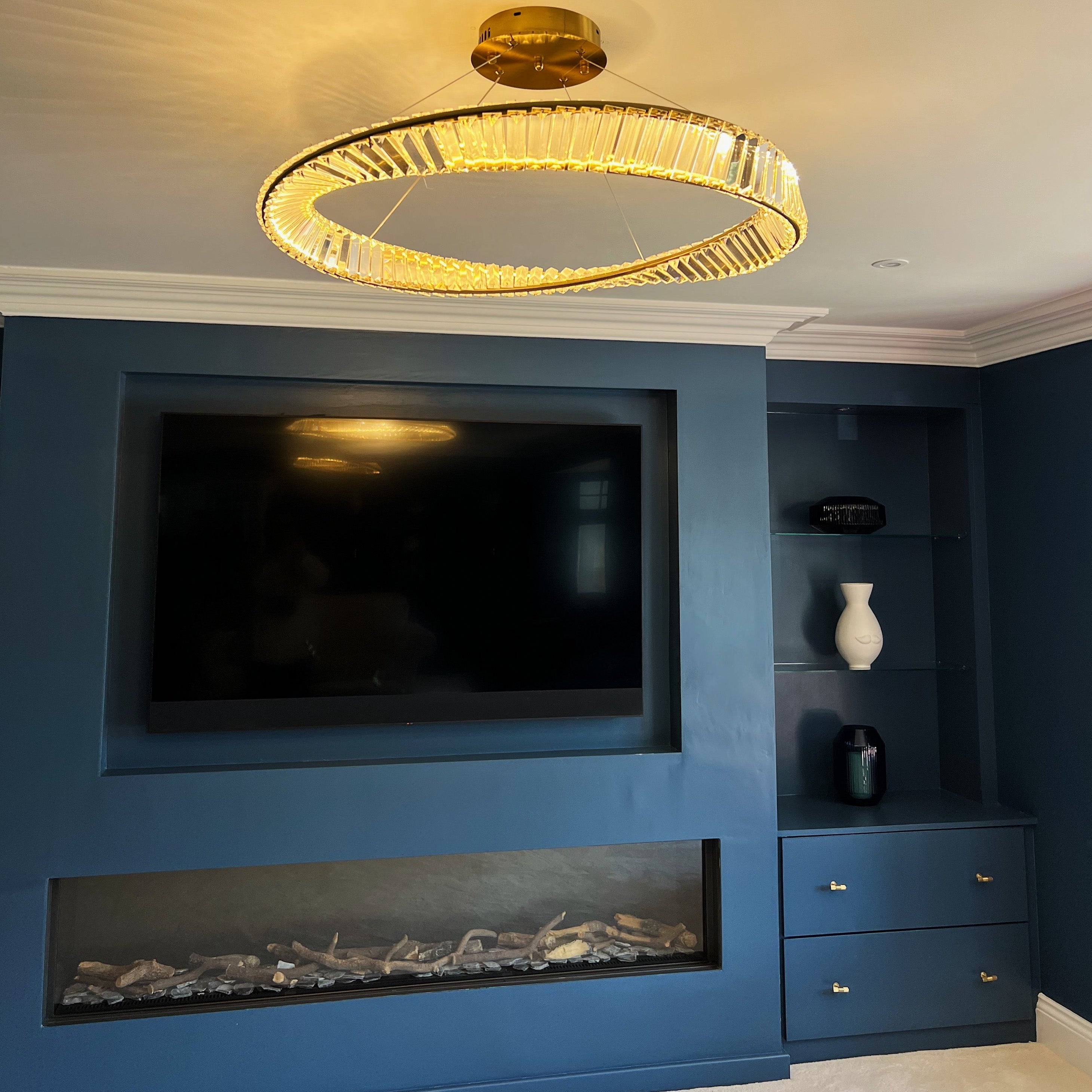 VORELLI Melia twisted circular chandelier creating warm ambient lighting above a modern media wall